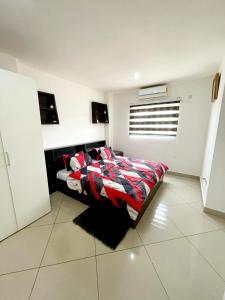 ein Schlafzimmer mit einem Bett mit einer Bettdecke darauf in der Unterkunft Regal Suites At Clifton Place in Accra