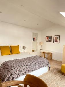 sypialnia z dużym łóżkiem z żółtymi poduszkami w obiekcie Beach & City - Trafaria w mieście Trafaria