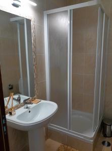 ein Badezimmer mit einem weißen Waschbecken und einer Dusche in der Unterkunft DeVVine Beach and Golf in Alvor + 15 Fotos