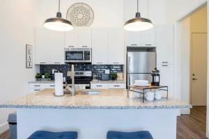 a kitchen with white cabinets and a stainless steel refrigerator at Cozy Atlanta Apartment in Atlanta