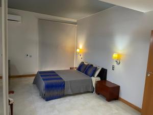 a bedroom with a bed with blue pillows at Marimar in Praia
