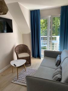 a living room with a couch and a chair at Villa PortoBianco in Pobierowo