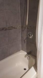 a shower in a bathroom with a white tub at Green&White House in Coquitlam