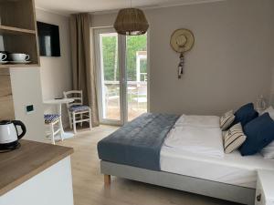 a bedroom with a bed and a kitchen with a balcony at Villa PortoBianco in Pobierowo