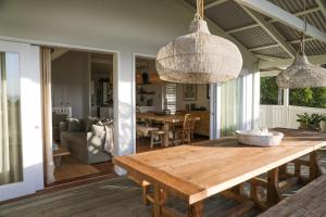a dining room and living room with a wooden table at Sirens in Byron Bay