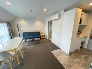 sala de estar con sofá azul y mesa en 2 on Whiteleigh and 239 on Lincoln Motel, en Christchurch