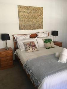 ein Schlafzimmer mit 2 Betten mit Kissen und einem Gemälde in der Unterkunft Griffin Getaway in Orange