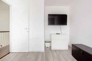 a living room with white walls and a flat screen tv at Lovely and comfortable Home Stay in London in London