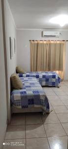 two beds sitting in a room with a window at Edificio Cesar en Eldorado por día in Eldorado