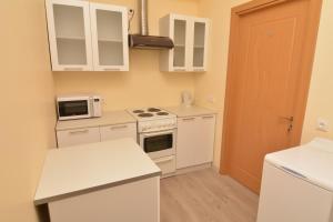 cocina con armarios blancos y fogones en Daukanto st 3 Kaunas Students Home LT en Kaunas