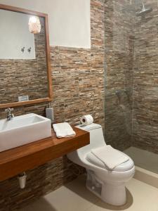 a bathroom with a toilet and a sink and a shower at Los Corales in Máncora +257 photos