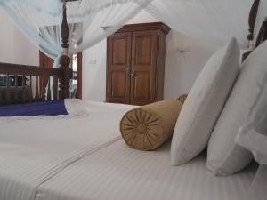 un letto bianco con cuscini sopra di Luxury Villa with BB Free WI-FI a Bentota