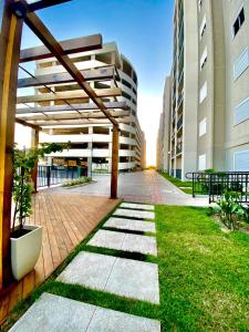 an empty courtyard of a building with grass and buildings at Apartamento Acqua, 102 A, com vaga de garagem in Pelotas