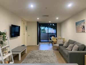 een woonkamer met een bank en een tafel bij Rooftop infinity pool - St Kilda luxury in Melbourne