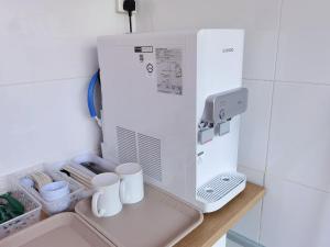 eine Kaffeemaschine in einer Küche mit Tassen auf einem Regal in der Unterkunft 3 mins to Garden City & Kubota Jln Apas Homestay in Tawau + 8 Fotos