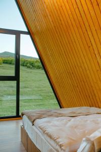 Bett in einem Zimmer mit einem großen Fenster in der Unterkunft TITA HOMES in Telawi
