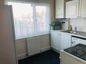 una pequeña cocina con fregadero y ventana en AC Lounge 119, en Rochford