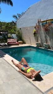 uma mulher de biquíni deitada numa piscina em Villa Lulu Geribá em Búzios