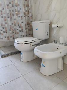 y baño blanco con aseo y bañera. en Duplex Bosch en Neuquén