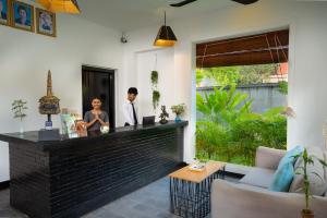 two people standing at a bar in a room at Bopha Wat Bo Residence in Siem Reap