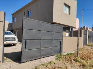 a black garage door on the side of a building at Duplex Bosch in Neuquén