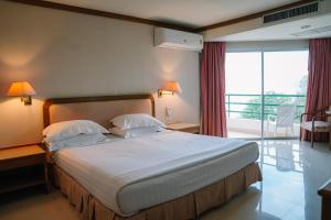 ein Hotelzimmer mit großem Bett und Balkon in der Unterkunft Khanom Golden Beach Hotel in Khanom