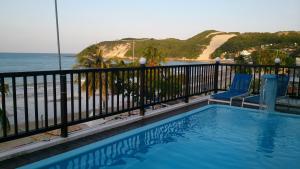uma piscina com vista para a praia em Hotel Pousada Azzurra em Natal