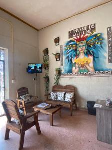 ein Wohnzimmer mit Stühlen und einem Gemälde einer Frau in der Unterkunft Garra Charrua in Mérida