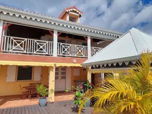 a house with a balcony and a patio at Villa Nautilia , vue mer, proche plage in Les Trois-Îlets