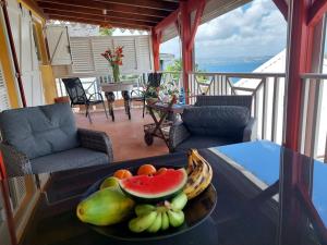 a bowl of fruit on a table on a balcony at Villa Nautilia , vue mer, proche plage in Les Trois-Îlets