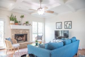 Una sala de estar con un sofá azul y una chimenea. en La Vaca Viva - Pool Side Oasis Near San Antonio, en Castroville