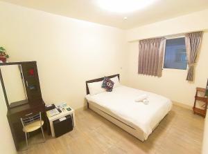 a small bedroom with a bed and a mirror at Especially chef's home B&B in Hualien City