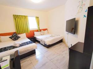 a room with two beds and a flat screen tv at Especially chef's home B&B in Hualien City +24 photos