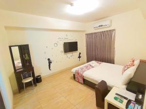 a bedroom with a bed and a tv on the wall at Especially chef's home B&B in Hualien City