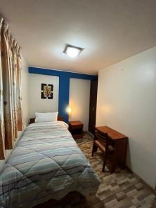 1 dormitorio con cama y escritorio. en Hostal Inkanto Taruma, en Tarma