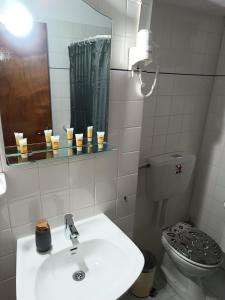 a bathroom with a sink and a toilet and a mirror at Voulias Αpartments in Kini