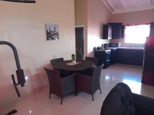 a living room with a table and chairs and a kitchen at Loodik Vacation Home Brompton Manor in Black River