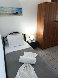 a bedroom with a bed with white towels on it at Voulias Αpartments in Kini