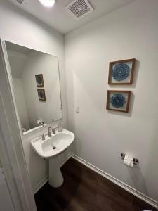 ein weißes Badezimmer mit einem Waschbecken und einem Spiegel in der Unterkunft Urban chic living minutes to I-45 and I-610 #B in Houston