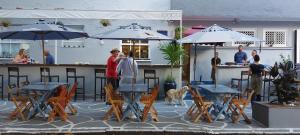 eine Gruppe von Menschen, die an einer Bar mit Sonnenschirmen stehen in der Unterkunft Hostel Leblon in Rio de Janeiro