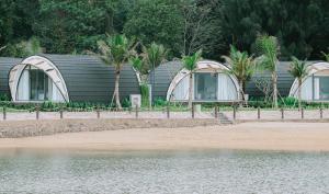 ein paar Gebäude an einem Strand neben dem Wasser in der Unterkunft Đầu Rồng Resort 