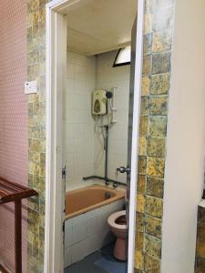 a bathroom with a bath tub and a toilet at SERI LAGENDA APARTMENT 3 in Kuah