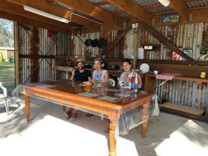 a group of people sitting around a large wooden table at BERTHA caravan River Heads in River Heads
