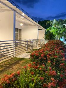 Ein Haus mit einem Zaun und einem Blumenstrauß in der Unterkunft LUTIX HOTELS in El Limón