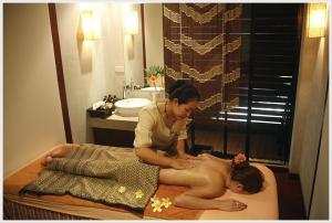 una mujer dándole un masaje a una mujer en una cama en Hansar Casuarina Cha am, en Puk Tian