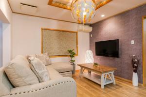 een woonkamer met een bank en een tafel bij condominium The First / Vacation STAY 81146 in Chatan