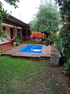 a backyard with a swimming pool and a wooden deck at Habitación privada cerca del centro in Godoy Cruz