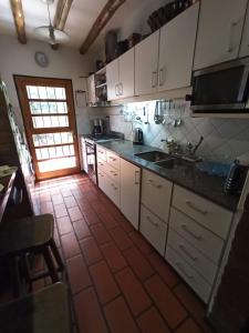 a kitchen with white cabinets and a tile floor at Habitación privada cerca del centro in Godoy Cruz