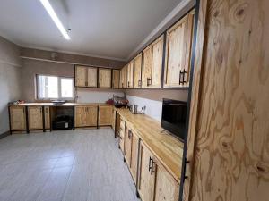 a kitchen with wooden cabinets and a counter top at Гостевой дом in Karakol