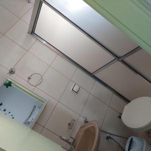 uma vista superior de uma casa de banho com um WC e um espelho em Recanto Panapaná - suítes em Águas de São Pedro